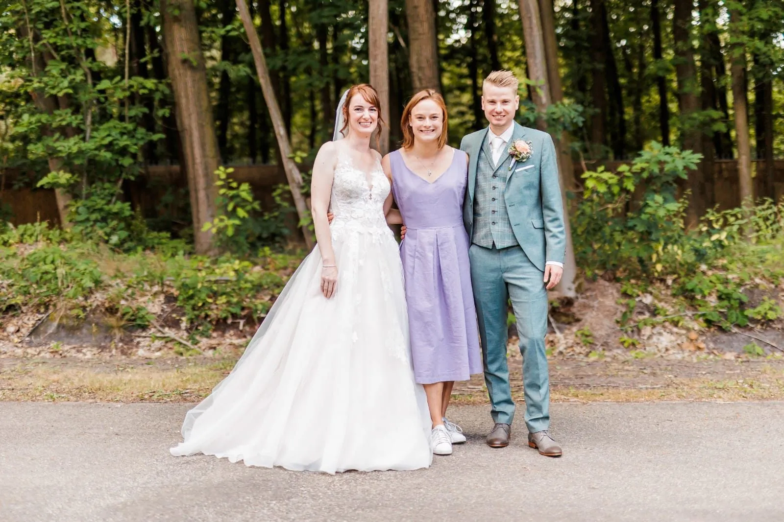 Bruidspaar samen met de ceremoniemeester op hun bruiloft